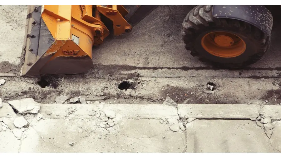 Close-up of an excavator working on road construction, showcasing the industrial process.